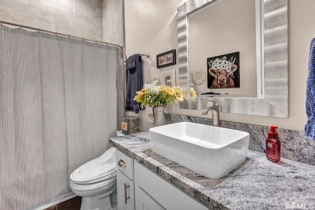 bathroom featuring vanity, toilet, and walk in shower