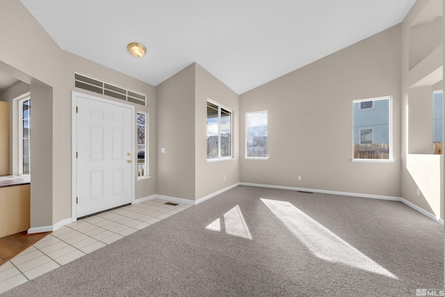 carpeted entryway featuring lofted ceiling