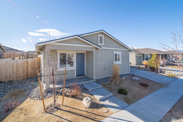 view of front of property featuring stucco siding and fence