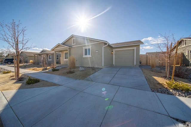 ranch-style house featuring stucco siding, an attached garage, driveway, and fence