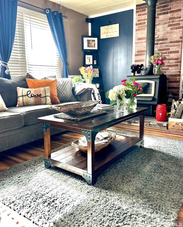 living room featuring a wood stove and wood-type flooring