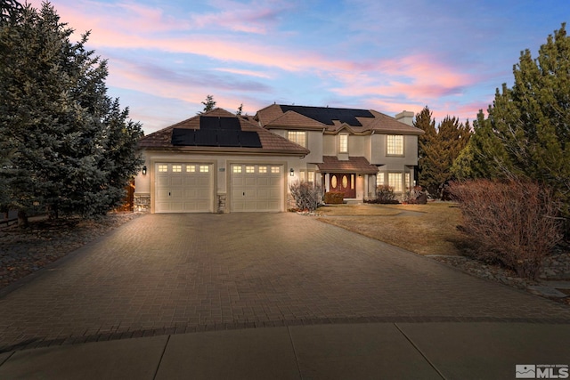 view of front of house featuring a garage and solar panels