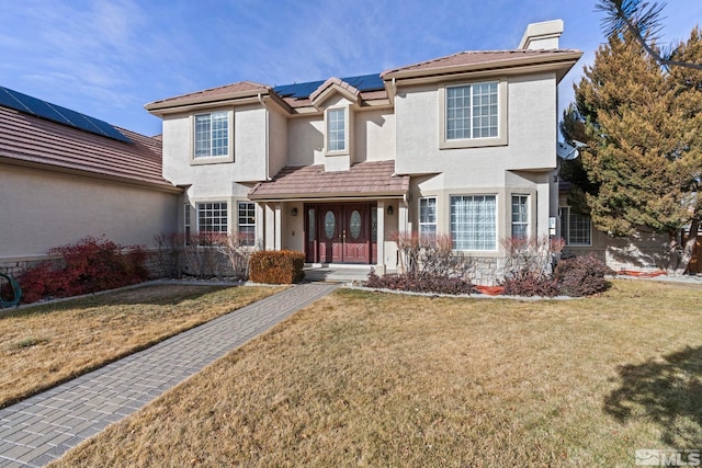 view of front property featuring solar panels and a front yard