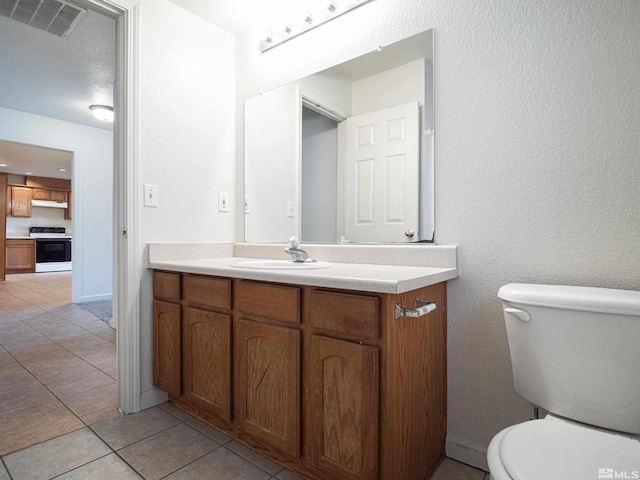 bathroom with vanity, visible vents, baseboards, toilet, and tile patterned floors