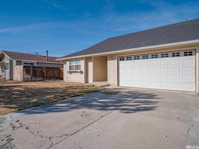 ranch-style house with fence, a shingled roof, driveway, and a garage