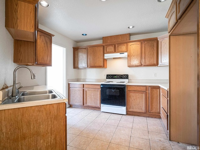 kitchen featuring a sink, electric range, and light countertops