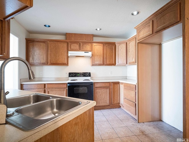 kitchen featuring electric range, brown cabinets, a sink, light countertops, and under cabinet range hood