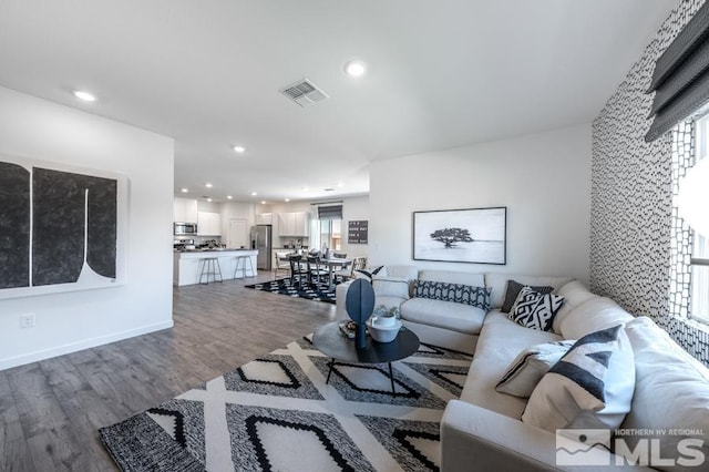 living area with visible vents, wood finished floors, and recessed lighting