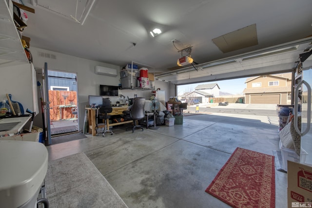 garage featuring visible vents, an AC wall unit, and a garage door opener