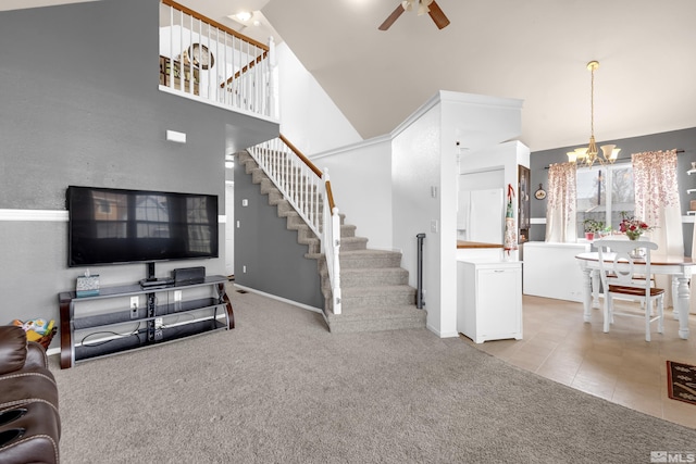 living room featuring light carpet, ceiling fan with notable chandelier, stairs, and a towering ceiling