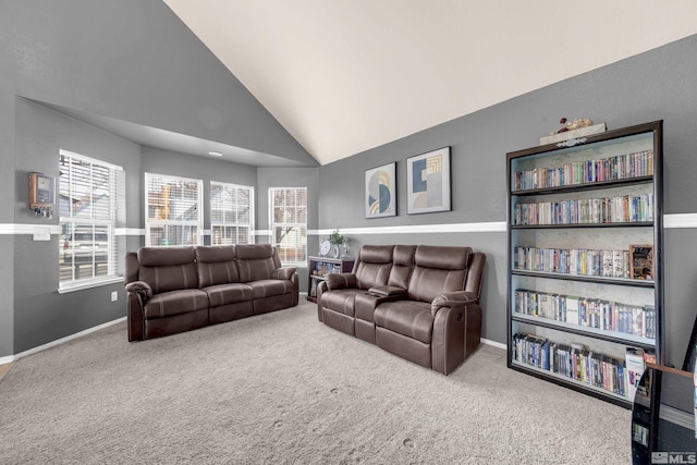 carpeted living area with high vaulted ceiling and baseboards