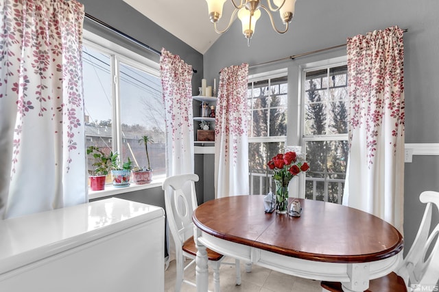 dining space featuring light tile patterned floors, vaulted ceiling, and a notable chandelier