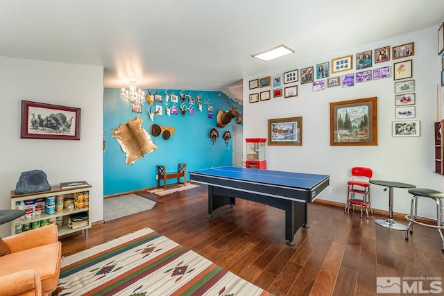 game room with a chandelier, dark wood finished floors, and baseboards