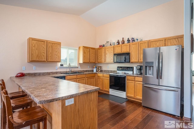 kitchen with stainless steel fridge, a peninsula, black microwave, a sink, and range with electric stovetop