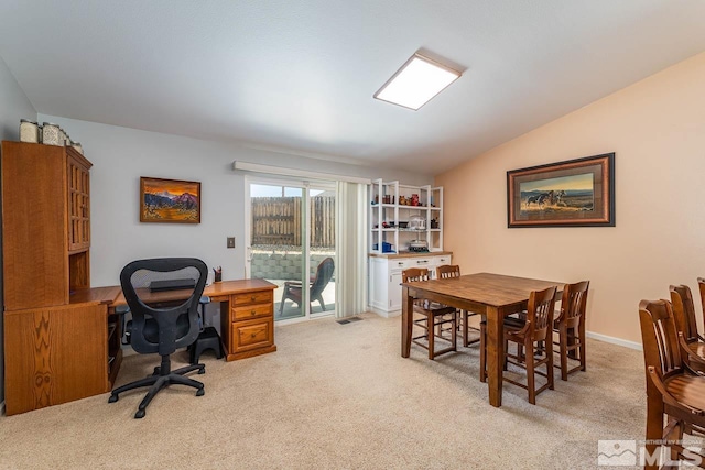 office area with lofted ceiling, baseboards, visible vents, and light colored carpet