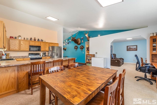 dining area with light carpet and vaulted ceiling