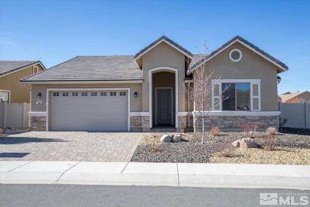 ranch-style home featuring stone siding, decorative driveway, an attached garage, and stucco siding