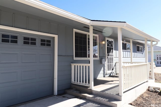 entrance to property with an attached garage, covered porch, and board and batten siding