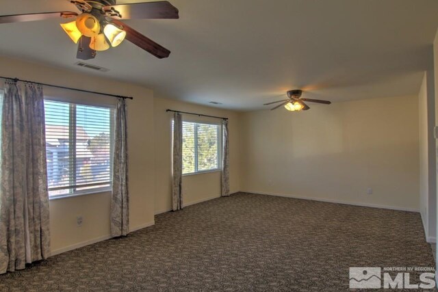 carpeted empty room featuring visible vents, baseboards, and ceiling fan