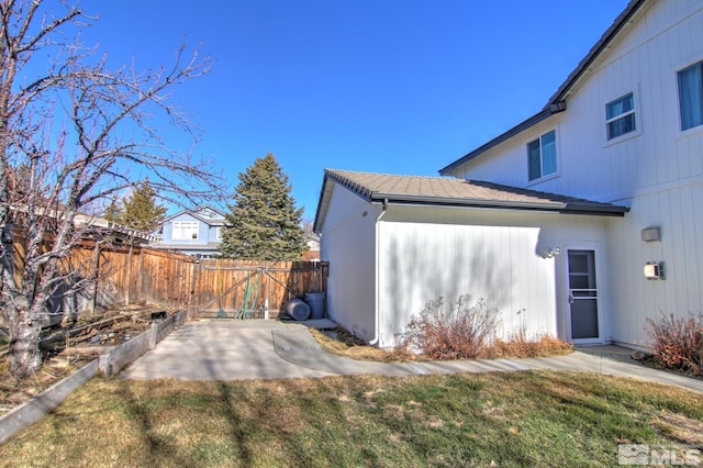 view of side of property featuring a lawn and fence