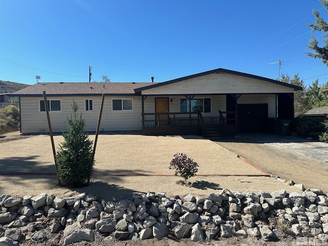 view of front of home featuring dirt driveway and an attached garage