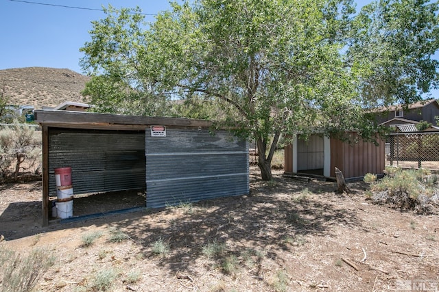 view of pole building with a mountain view and fence