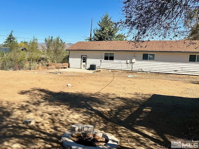 rear view of house with a fire pit, a patio, and central AC unit