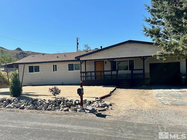 single story home featuring a garage, a mountain view, and concrete driveway