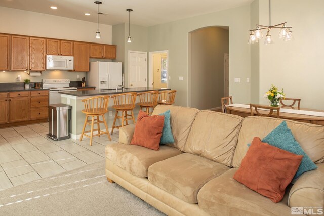 living room featuring arched walkways, light tile patterned floors, and recessed lighting