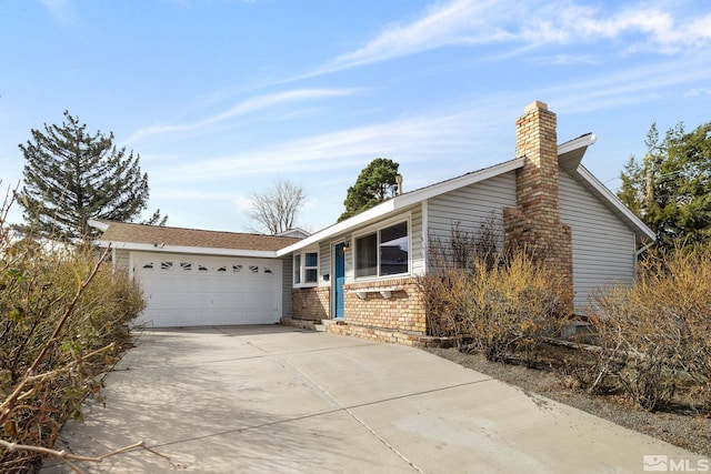 ranch-style house with a garage, concrete driveway, brick siding, and a chimney