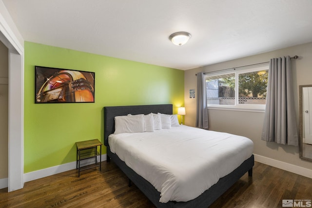 bedroom featuring dark wood finished floors and baseboards