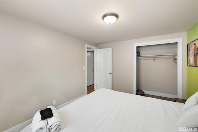 bedroom featuring baseboards and a closet