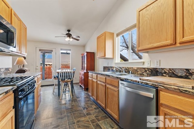 kitchen with a ceiling fan, stone finish flooring, stainless steel appliances, light brown cabinets, and a sink