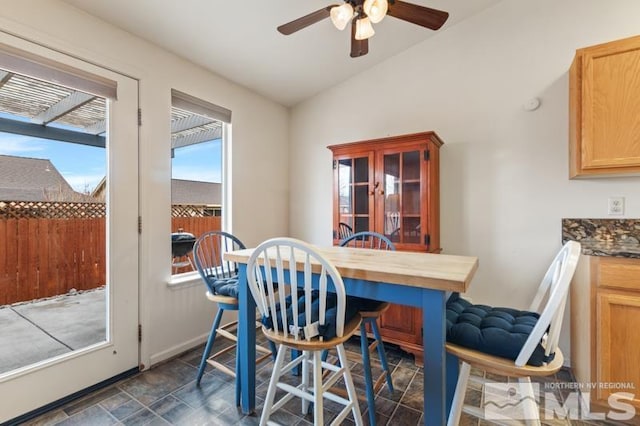 dining room with lofted ceiling, ceiling fan, and baseboards