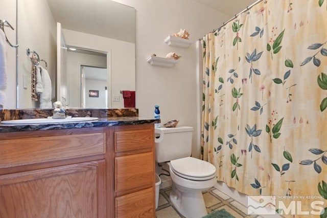 full bath with toilet, tile patterned floors, curtained shower, and vanity