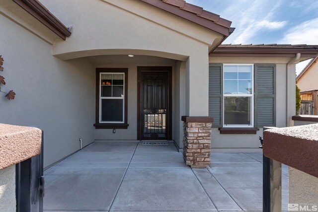 property entrance featuring a patio and stucco siding