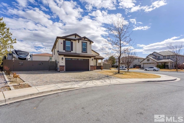 view of front of property featuring brick siding, stucco siding, an attached garage, fence, and driveway