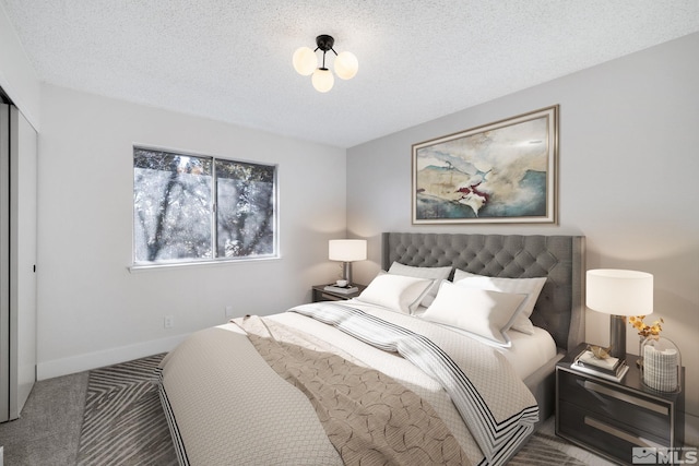 carpeted bedroom with baseboards and a textured ceiling