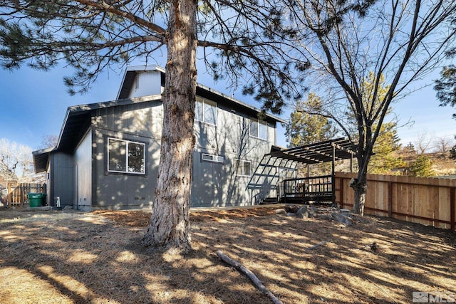 back of house with fence and a pergola