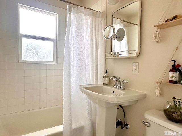 full bathroom with a sink, toilet, and shower / bath combo with shower curtain