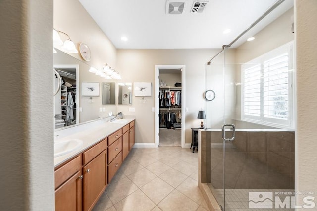 bathroom featuring double vanity, visible vents, a sink, and tile patterned floors