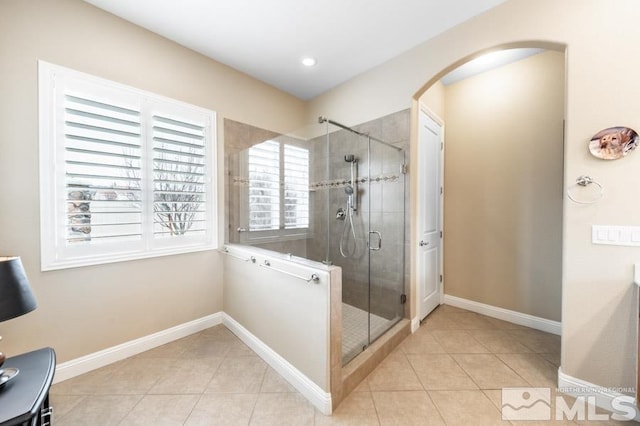 bathroom featuring baseboards, a shower stall, and tile patterned floors