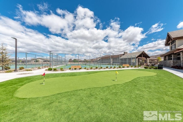 view of property's community featuring a tennis court, a water view, and fence