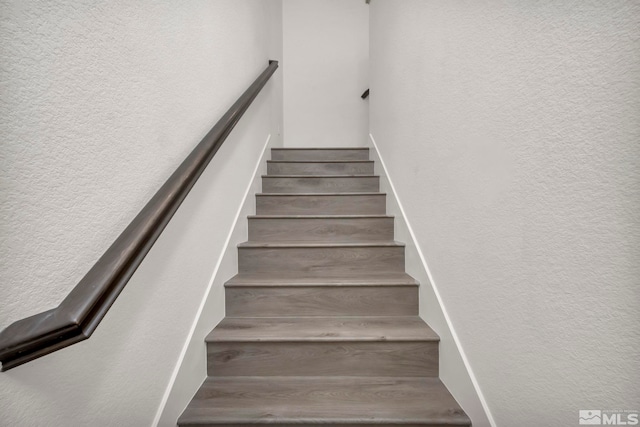 staircase featuring a textured wall