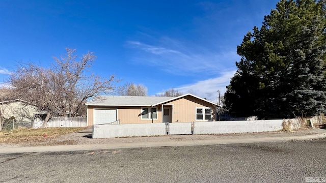 view of front of property with a fenced front yard and a garage