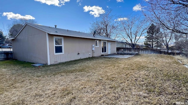 rear view of house featuring a lawn, a patio area, and a fenced backyard