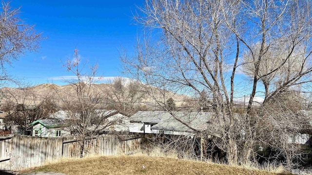 view of yard featuring a mountain view and fence