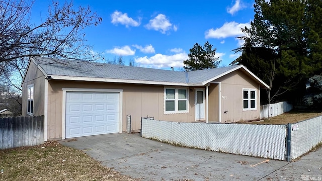 ranch-style house with an attached garage, a fenced front yard, and concrete driveway