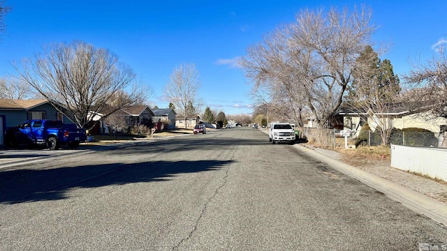 view of road with a residential view, curbs, and sidewalks