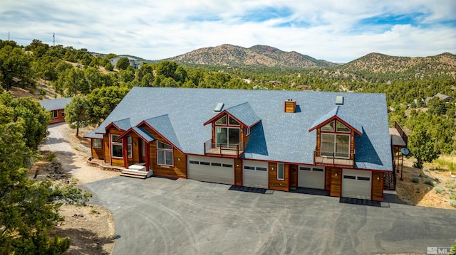 view of front of house featuring aphalt driveway, a chimney, and a mountain view